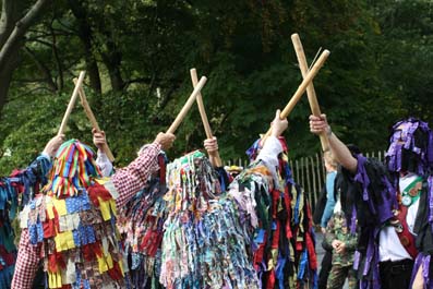 Crook in Border morris rags, brandishing sticks